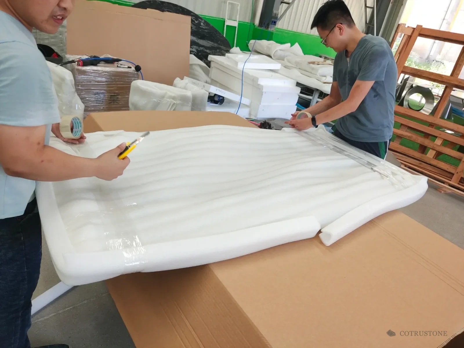 Protective foam being wrapped around a curved stone component