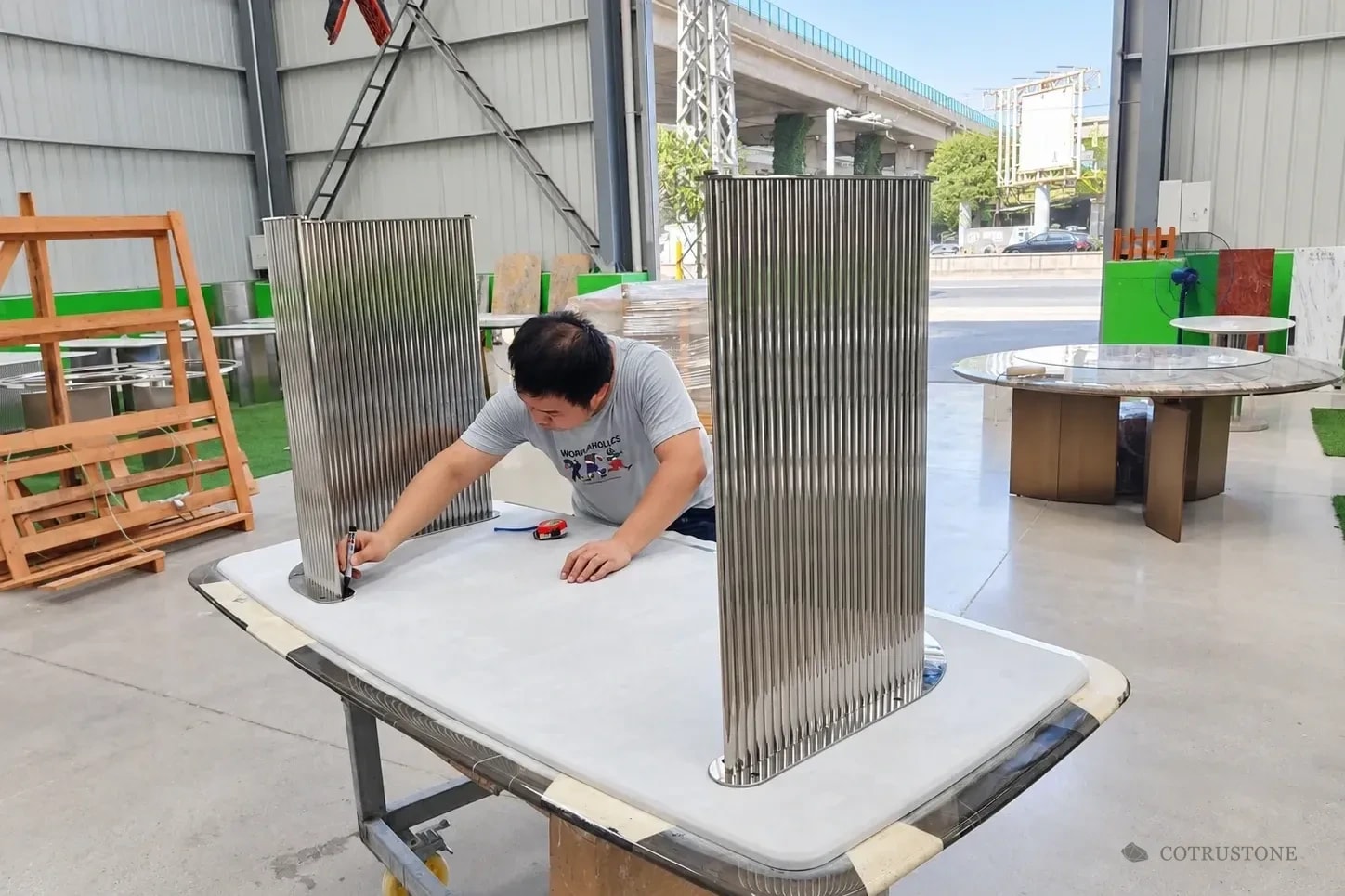 Worker checking the base connection on the underside of a stone tabletop