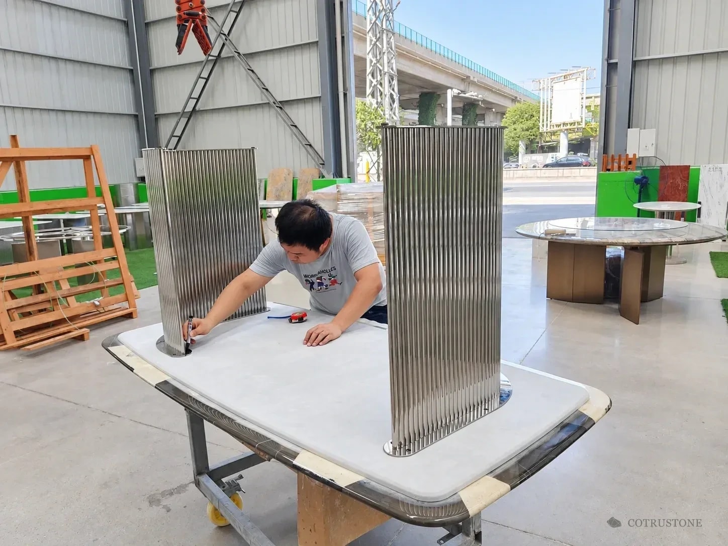 Worker checking the base connection on the underside of a stone tabletop
