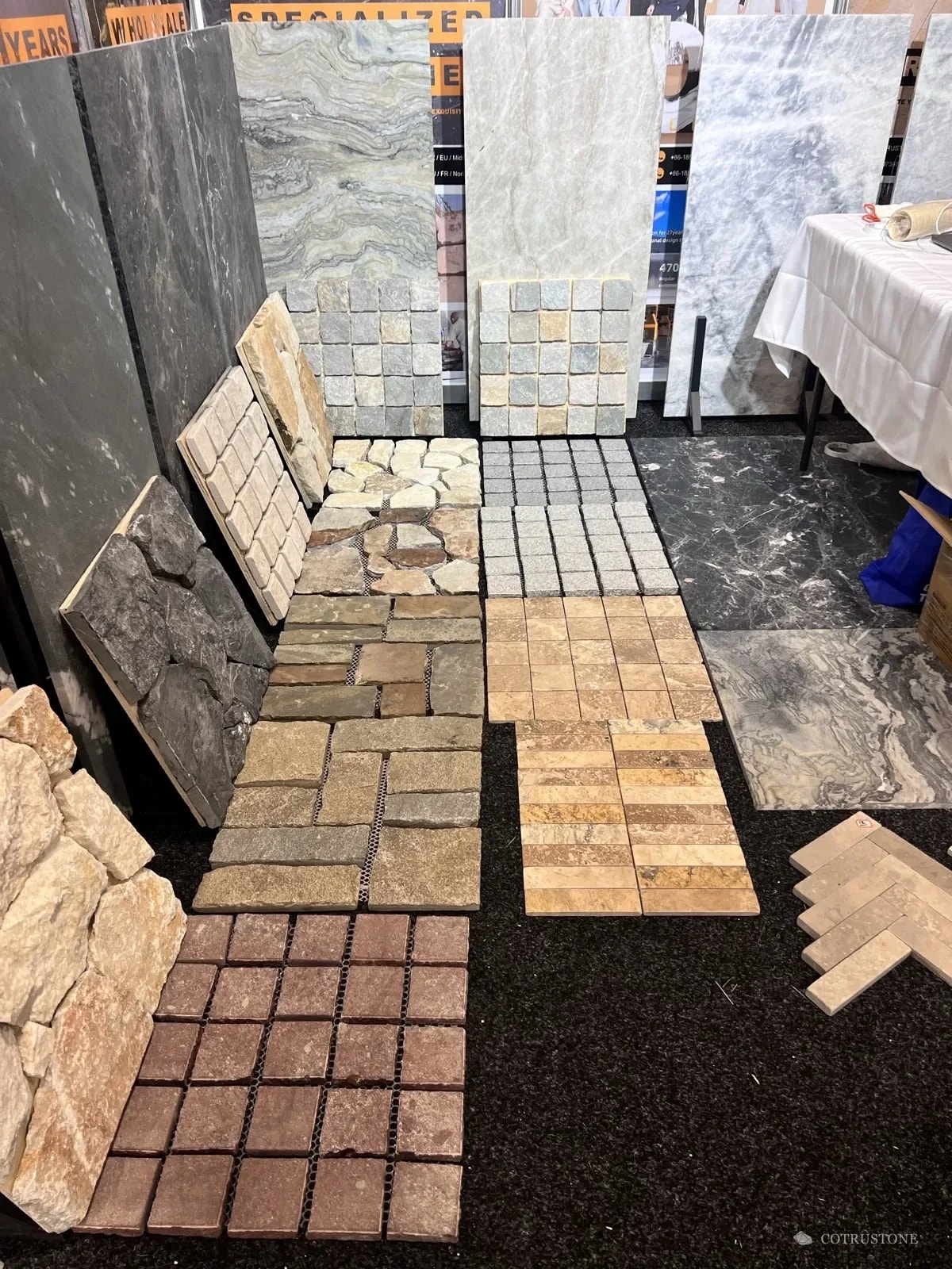 Stone slabs, mosaics and tile samples arranged at the Cotrustone exhibition display in Sydney