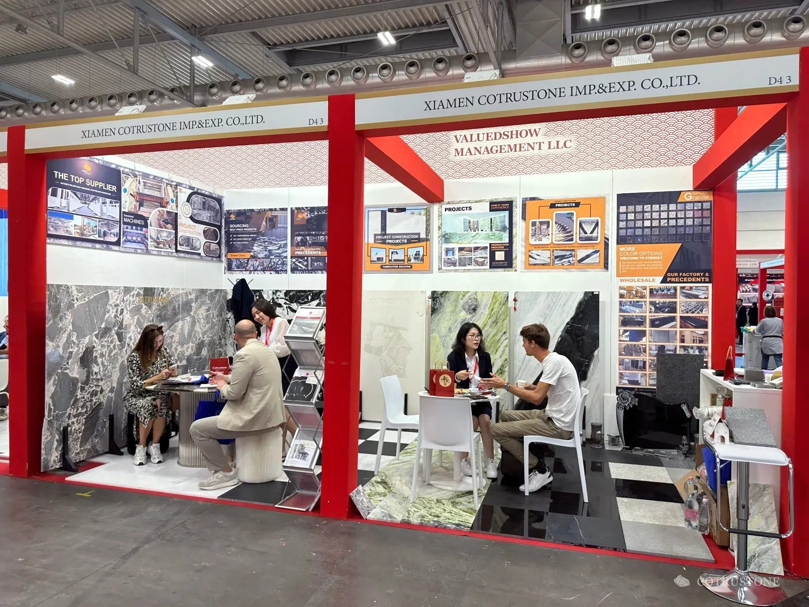 Cotrustone exhibition stand in Verona in 2023, showing marble panels, stone furniture and seated conversations