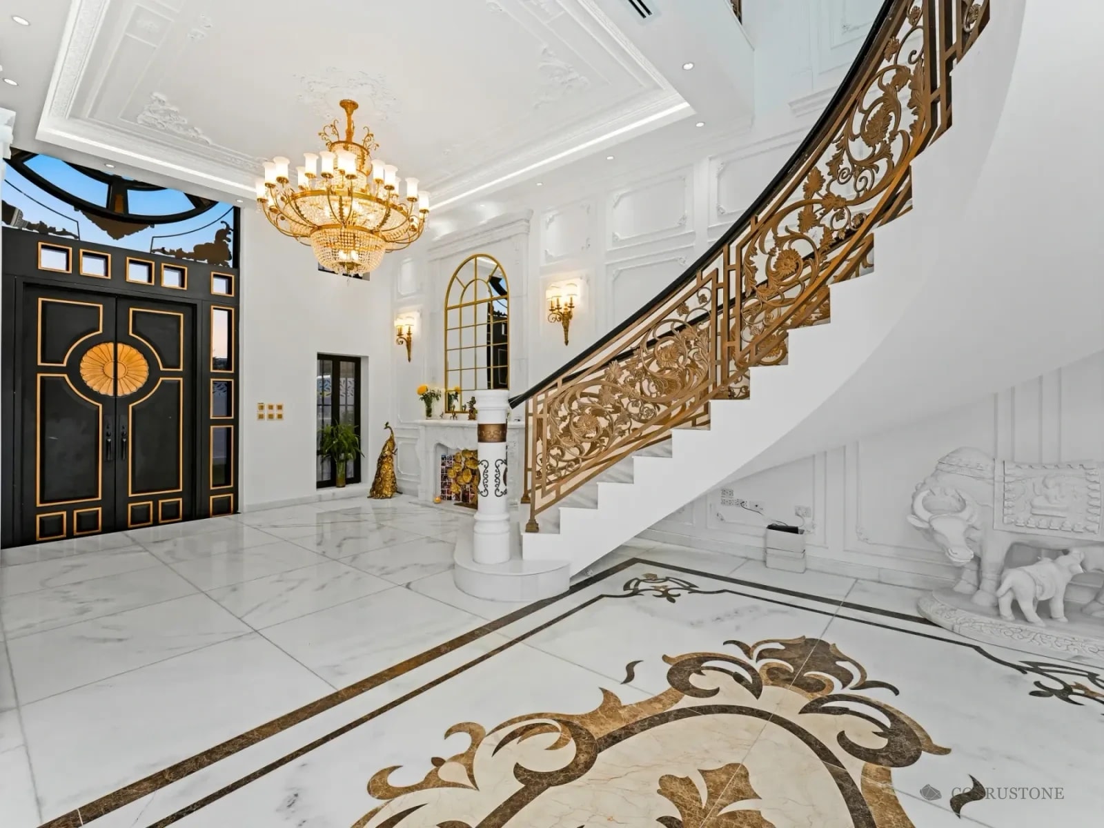 Stone stair, marble flooring with decorative inlay and carved stone details in a residence