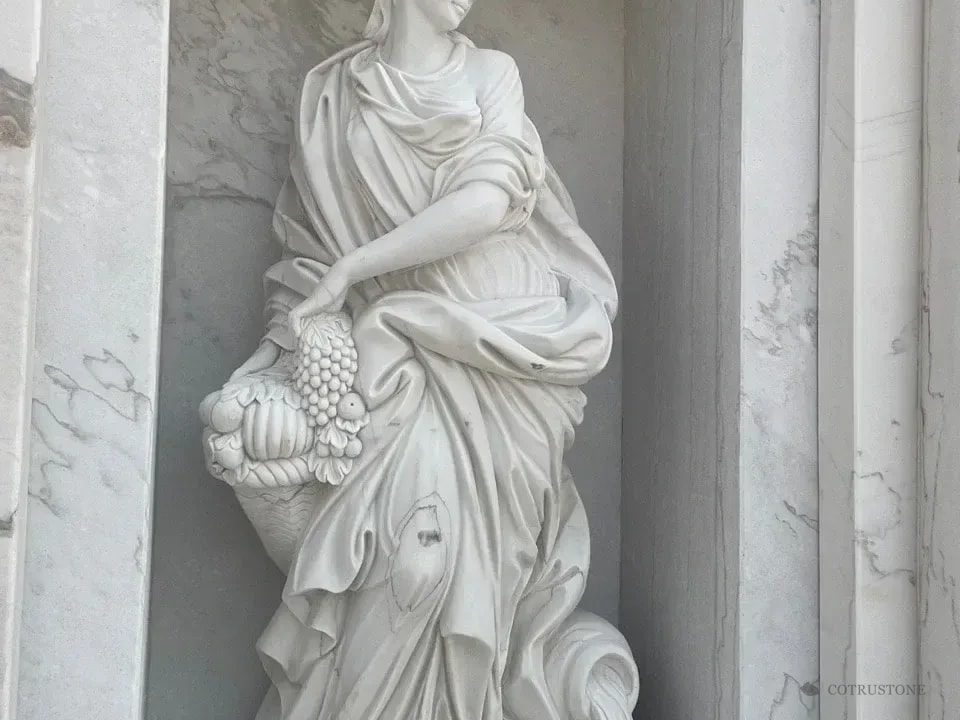 Carved stone figure framed by a marble niche