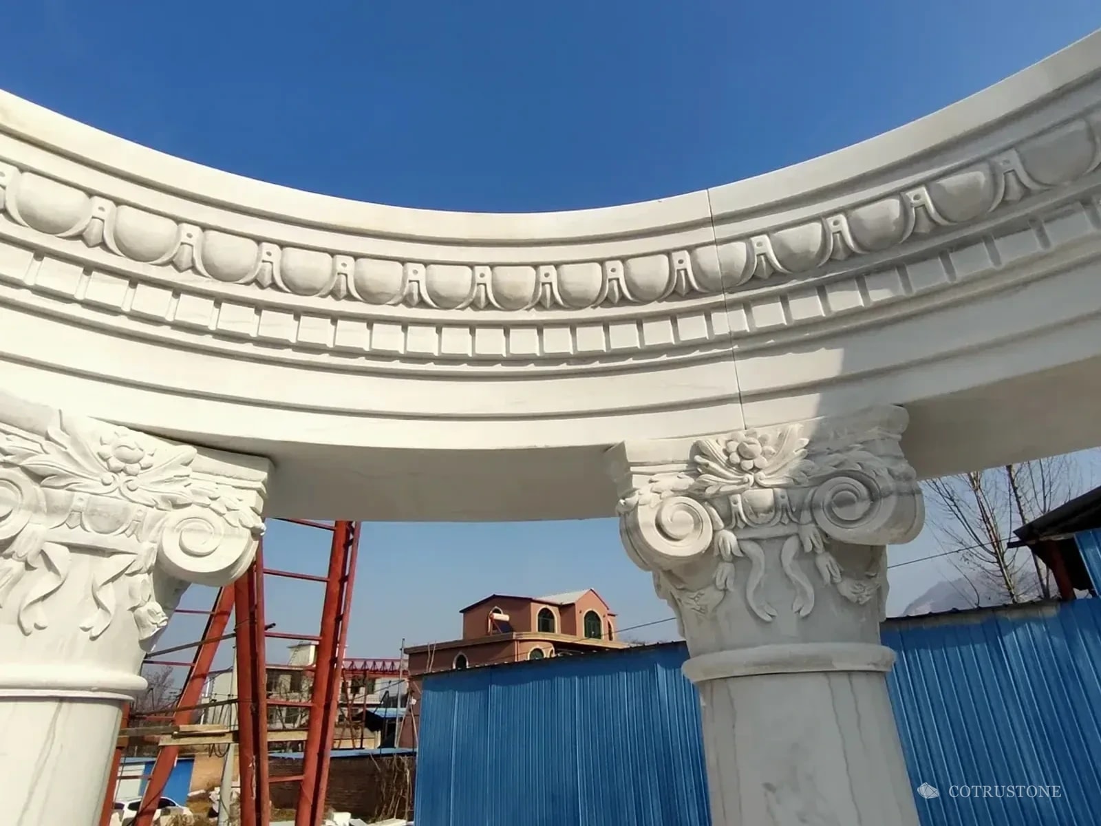 Close view of carved stone capitals and curved cornice joints