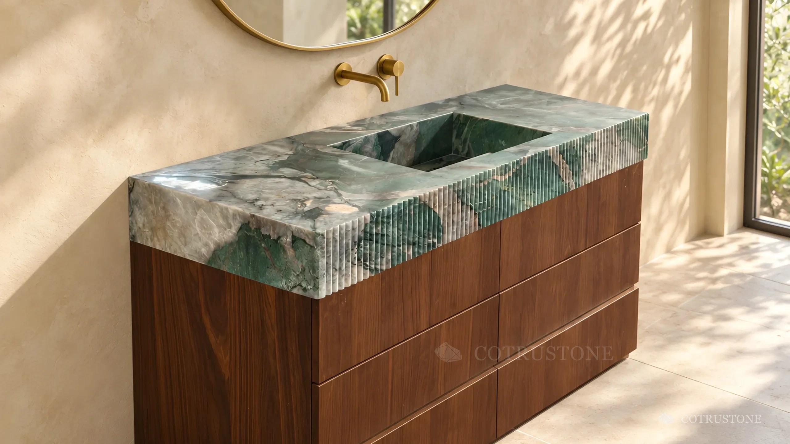 Cubierta de piedra verde con vetas, borde acanalado y lavabo integrado, sobre un gabinete de nogal de seis cajones