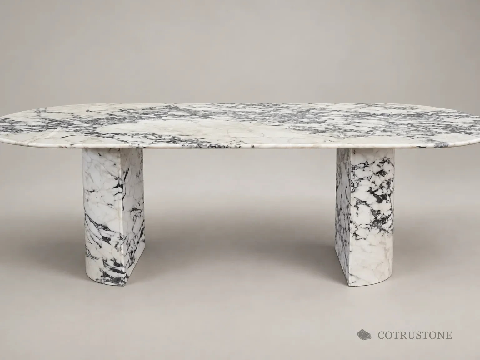 Curved stone table with black and grey veining and two half-round pedestal supports