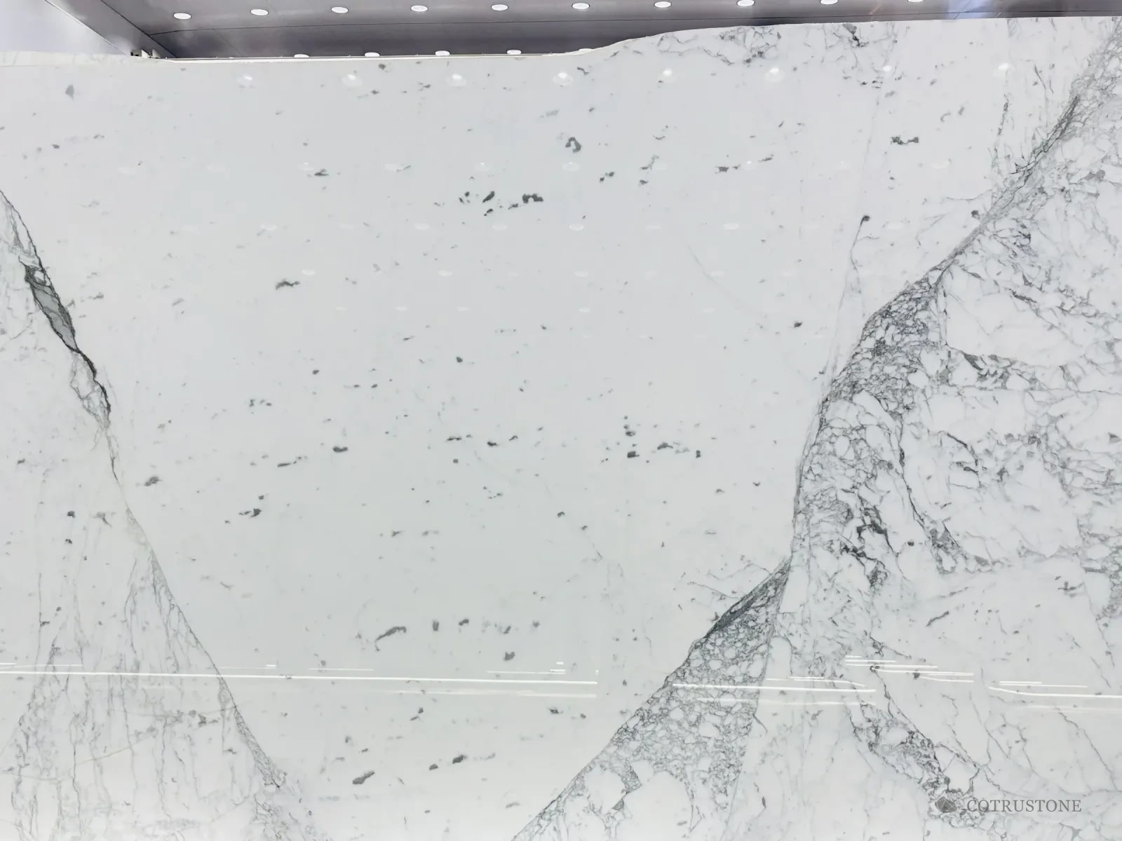 A full slab of Statuario marble on the stand, bold grey veins meeting in a V