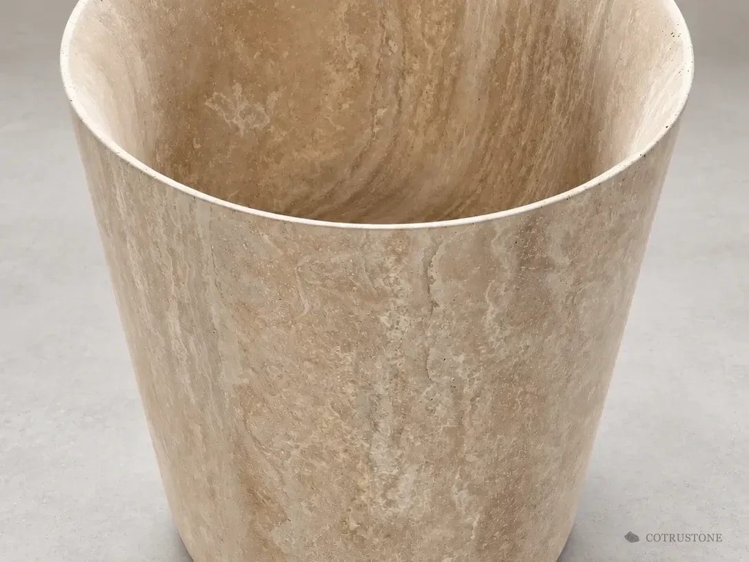 Tapered travertine pedestal basin with continuous natural veining and a wide oval bowl