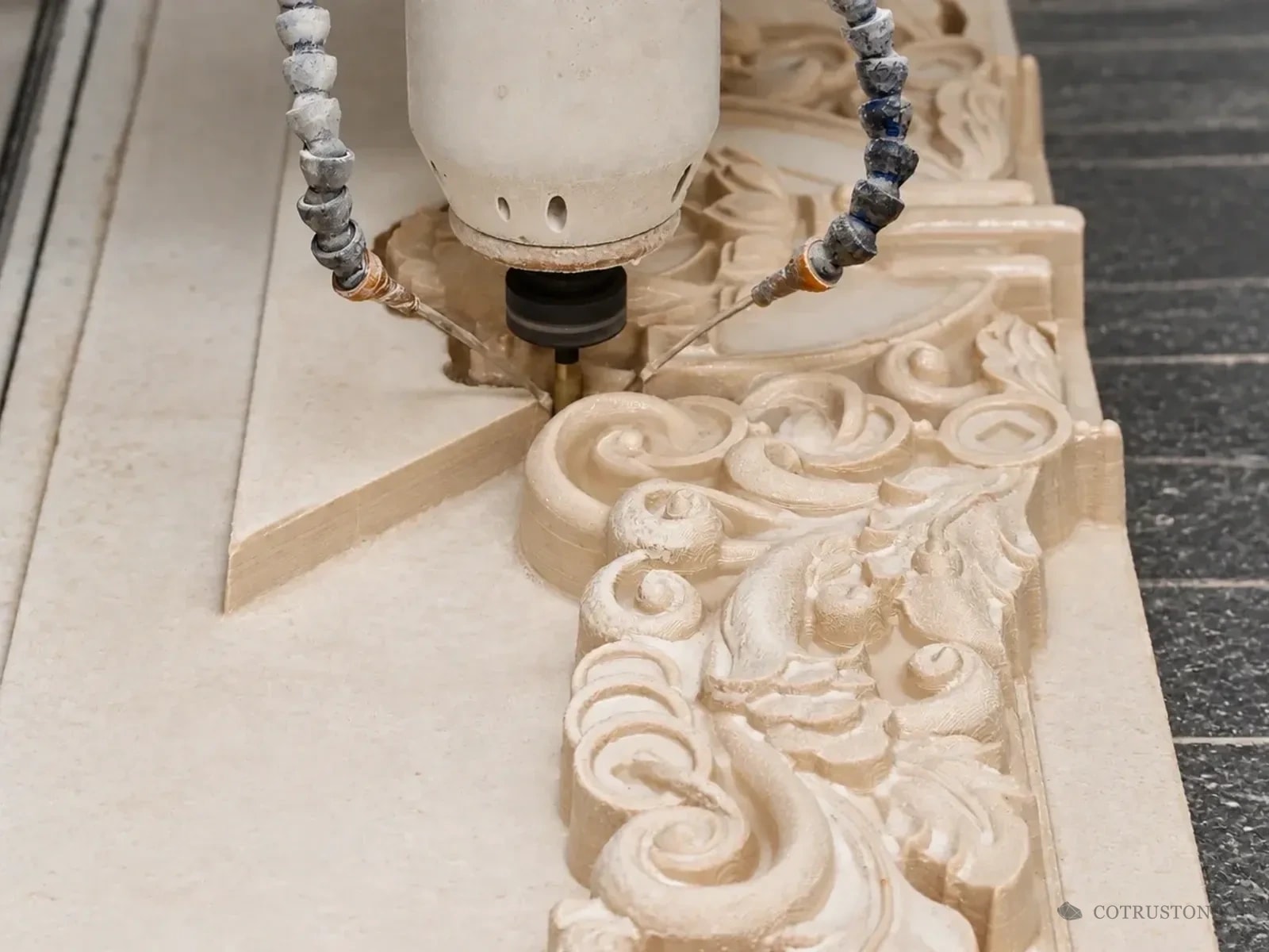 Machining head shaping a floral stone relief