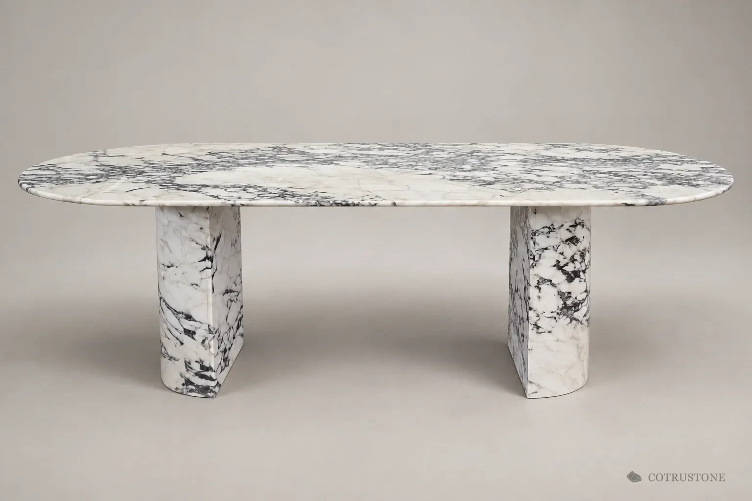 Curved stone table with black and grey veining and two half-round pedestal supports